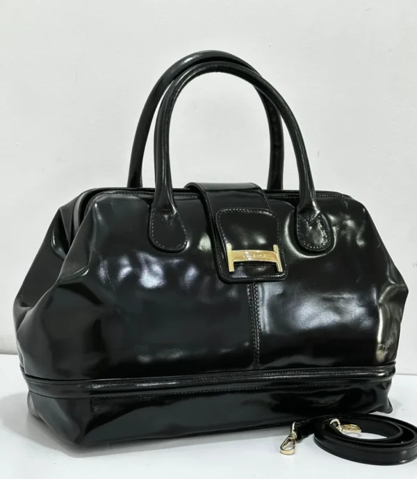 Black patent leather doctor bag with gold buckle logo plate and rolled handles, Nigeria Black patent leather doctor bag with gold buckle logo plate and rolled handles, Nigeria