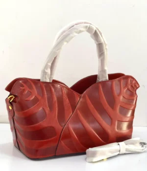 Sculptural leaf embossed leather tote bag red rust with arc top handles and gold hardware Nigeria