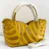 Sculptural leaf embossed leather tote bag yellow mustard with arc top handles and gold hardware Nigeria