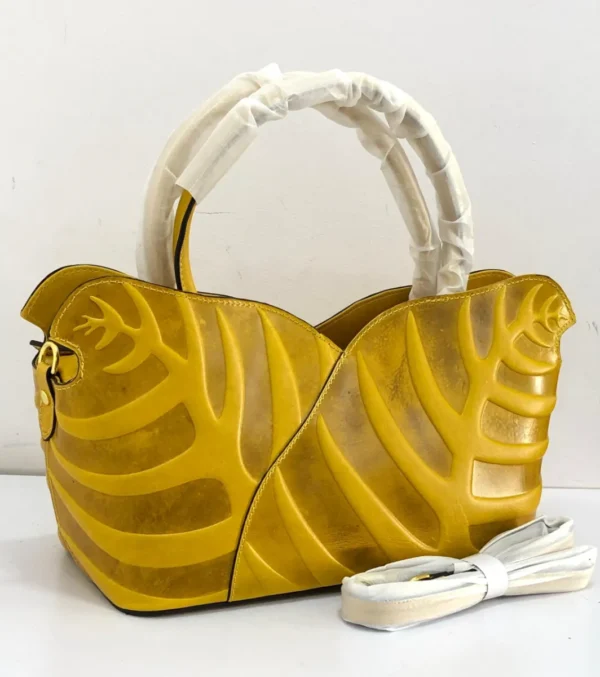 Sculptural leaf embossed leather tote bag yellow mustard with arc top handles and gold hardware Nigeria