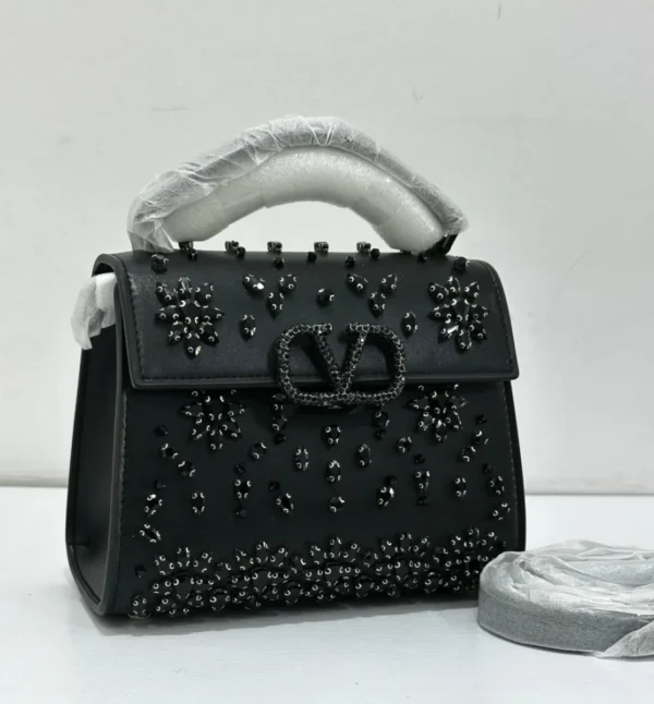 Valentino Garavani VSling crystal embellished top handle bag black leather with black crystal floral detail and gunmetal VLogo hardware Nigeria